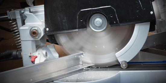 A saw cutting an aluminum extrusion