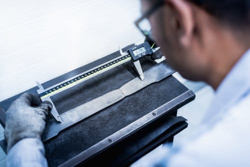 Engineer using digital vernier to measure the elongation of a material