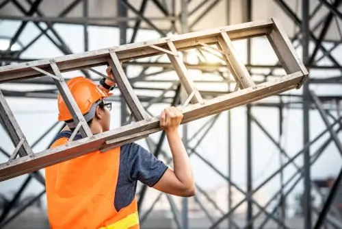 Worker carrying aluminum step ladder