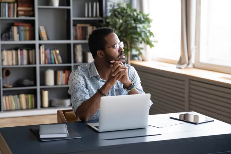 Man at laptop, thinking