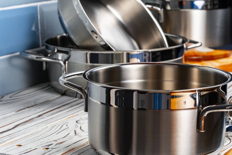 Set of aluminum cookware on kitchen counter close up
