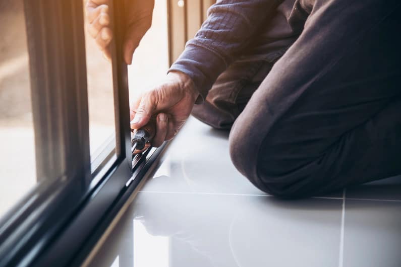 Man working on aluminum window frame