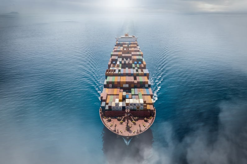 Cargo ship on ocean surrounded by fog