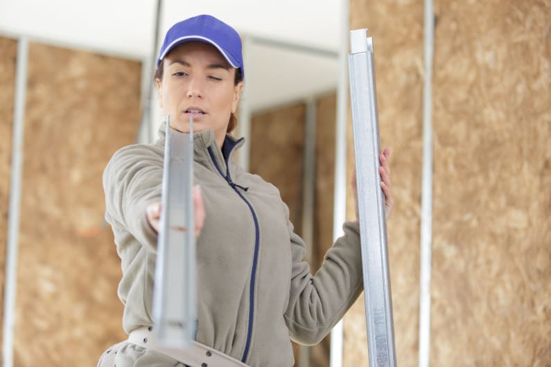 Female builder examining aluminum extrusion