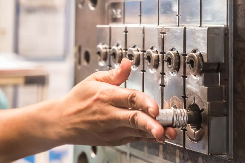 Worker inserts spare parts into Injection molding machine